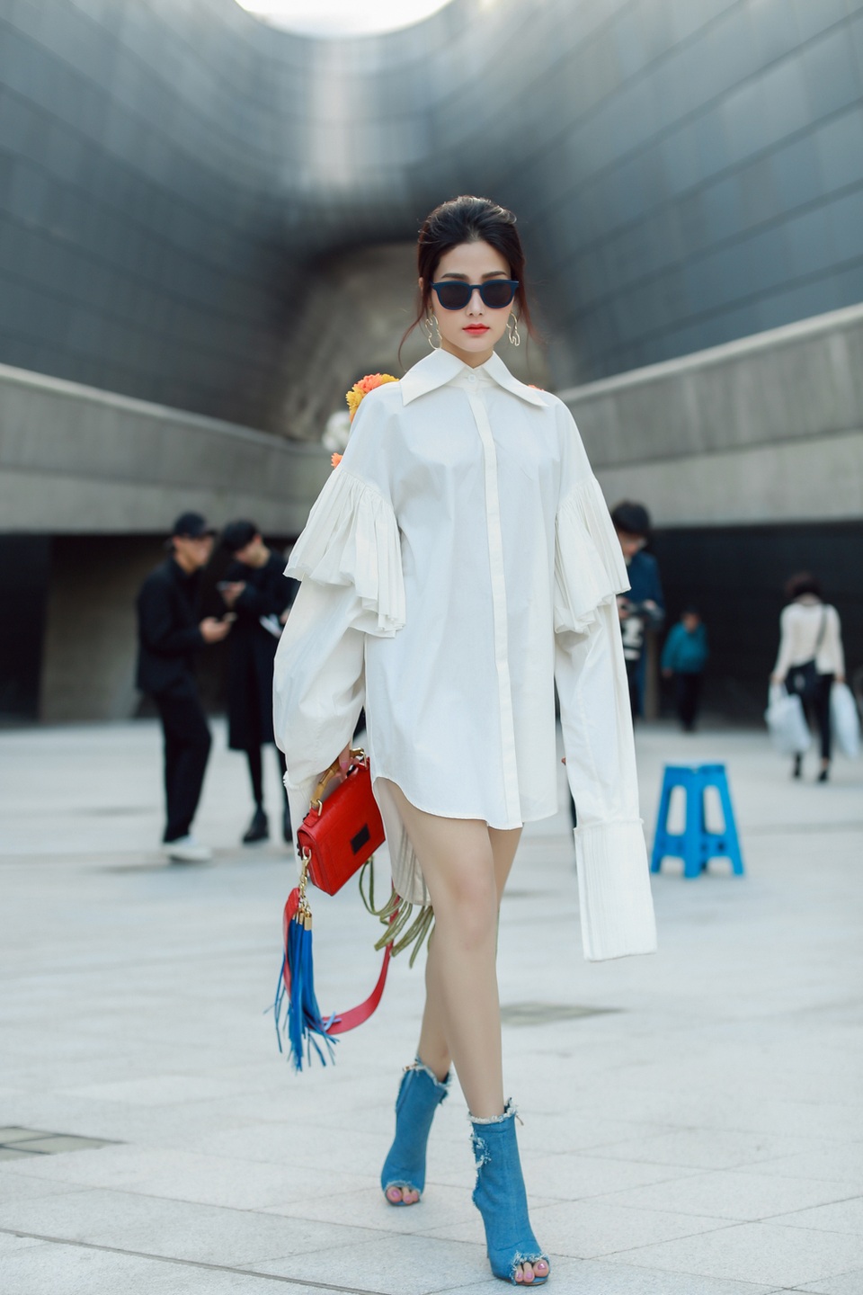 Ở bộ cánh này, người đẹp lựa chọn phụ kiện gam màu nổi bật hơn với giày boot hở mũi và túi xách đỏ tươi.