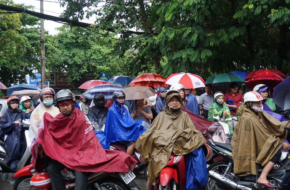 Phụ huynh “đội nắng, đội mưa” chờ con làm bài thi - 7 Các phụ huynh mang áo mưa, che ô chờ con trước cổng Trường THPT Huỳnh Thúc Kháng