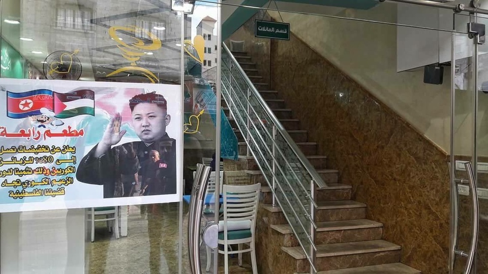 Người hâm mộ nhiệt thành của ông Kim Jong-un ở dải Gaza - 1 Tấm hình quảng cáo treo hình ông Kim Jong-un trước một cửa hàng ở dải Gaza. (Ảnh: Twitter/Ali)