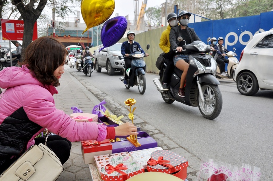 Hoa hồng dát vàng giá 60 nghìn đồng bán nhiều trên vỉa hè Hà Nội - 6
Năm nay hoa hồng dát vàng có khá nhiều mẫu mã. Ngoài loại đựng trong hộp giấy còn có thêm nhiều loại như hoa hồng dát vàng sô-cô-la, hoa hồng vàng có chữ “I love you” hay các loại hoa dát vàng nhiều màu sắc cho khách lựa chọn. Theo nhiều chủ cửa hàng, do có quá nhiều quán bán nên đã giám giá “kịch sàn”, tuy nhiên sức tiêu thụ vẫn kém. Trong ảnh là hoa hồng dát vàng có đế được chào bán 120.000 đồng/bông tại phố Xuân Thủy, Cầu Giấy.