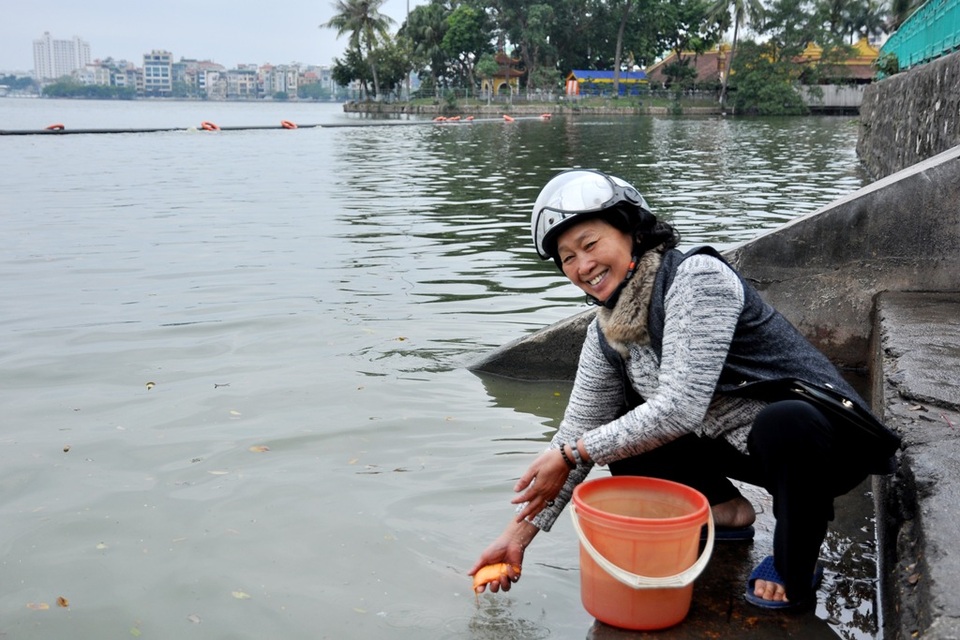 Nhà sư bám trụ hồ Tây xin rác người thả cá tiễn Táo quân - 9
Bà Trần Thị Cầu (Ba Đình, Hà Nội) vui vẻ phóng sinh cá chép xuống hồ. Năm nay bà Cầu quyết định không mang theo túi nilon để tránh việc xả rác ra môi trường.
