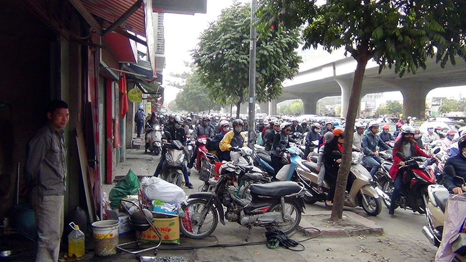 Ngày đầu đi làm sau Tết: Đường vành đai 3 ùn tắc nghiêm trọng - 8 Một cửa hàng sửa chữa xe máy đem xe chắn ngang vỉa hè để ngăn dòng người điều khiển xe máy đi qua trước cửa nhà