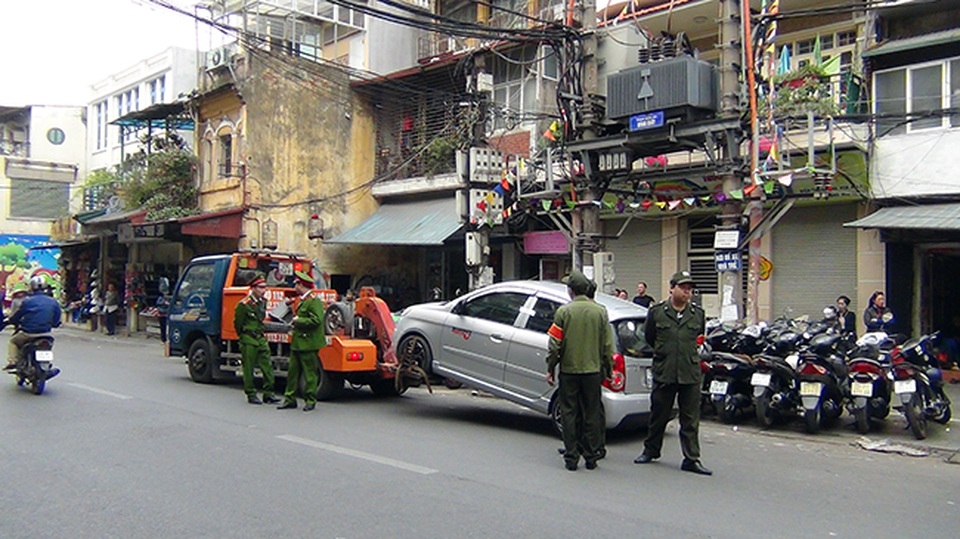 Hà Nội “ra quân” giành lại vỉa hè ở khu trung tâm - 16 Một chiếc ô tô vô chủ đỗ trái phép dưới lòng đường bị cẩu về đồn.