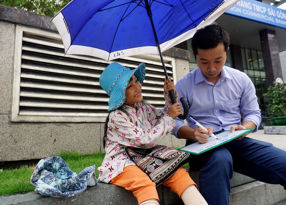 Nhân viên ngân hàng dành giờ nghỉ trưa dạy chữ cho bé bán vé số giữa Sài thành - 2 Lớp học chỉ 1 thầy, 1 trò nhưng nhiều niềm vui. Bất kể mưa, nắng, cô bé có làn da đen nhẻm nhưng nụ cười tươi và đôi mắt trong sáng vẫn đều đặn đến học cùng thầy Tú.