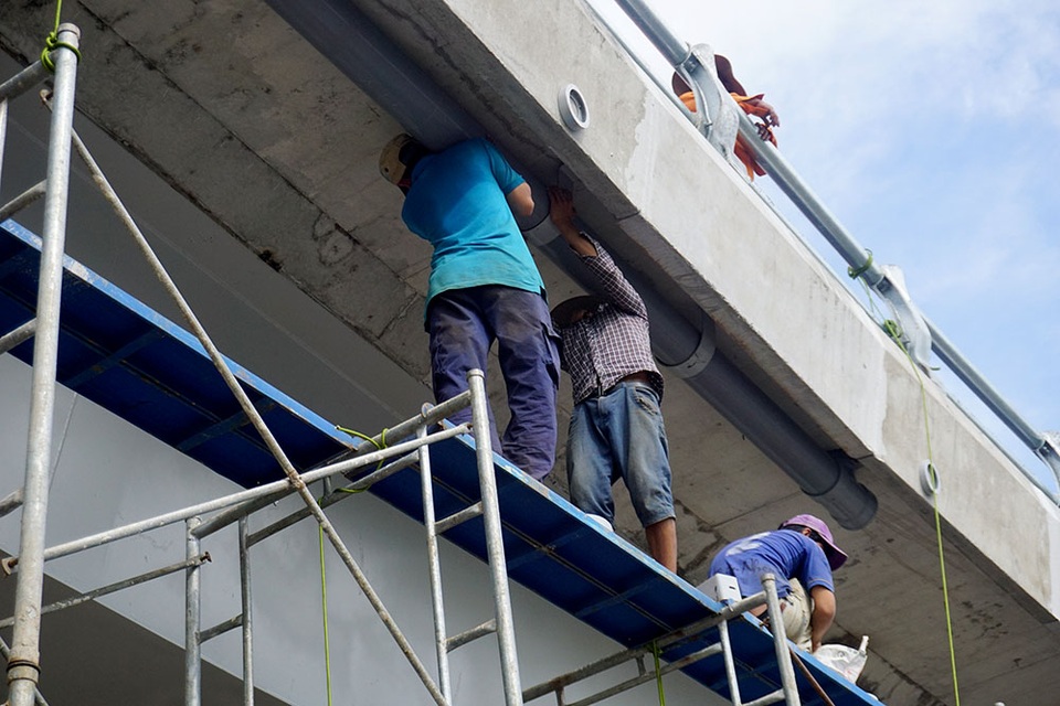 Thi công, lắp đặt hệ thống chiếu sáng và thoát nước trên cầu.