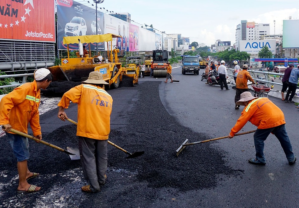 Các công nhân đang rải nhựa trên mặt cầu chiều 28/6.