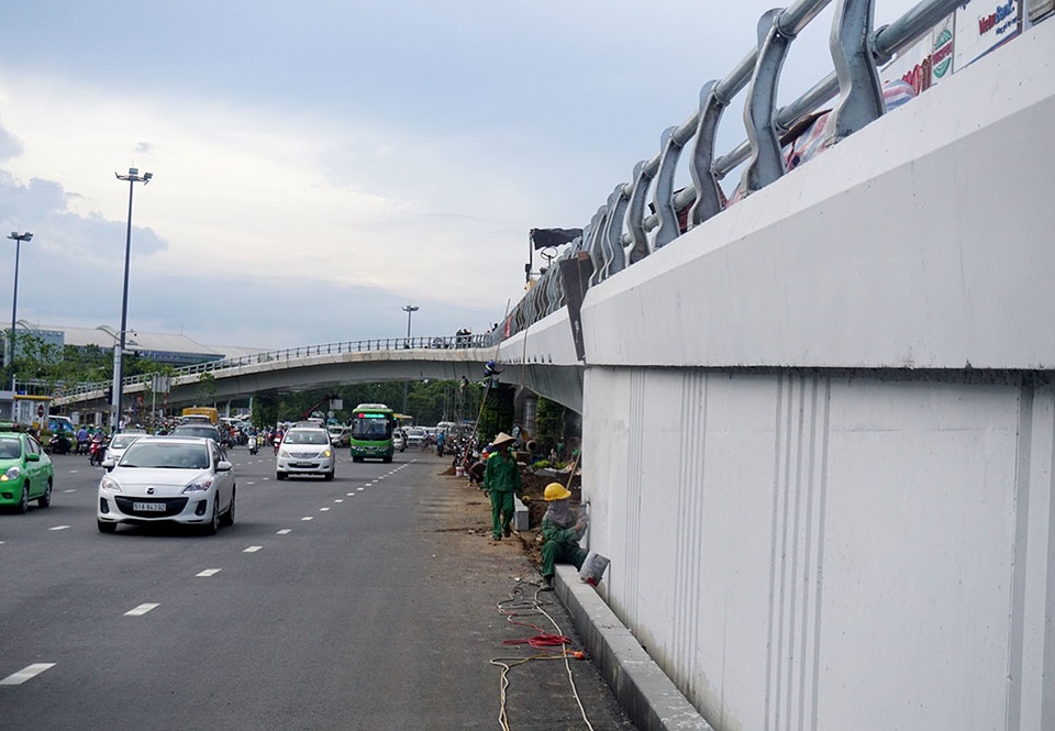 Dự kiến, công trình sẽ thông xe và khánh thành ngày 3/7. Các công nhân đang tẩy những vết bẩn bám trên thành cầu.