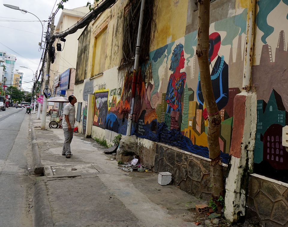 Một người đàn ông đang nhìn ngắm những hình vẽ ở góc đường Mai Thị Lựu-Nguyễn Đình Chiểu, quận 1.