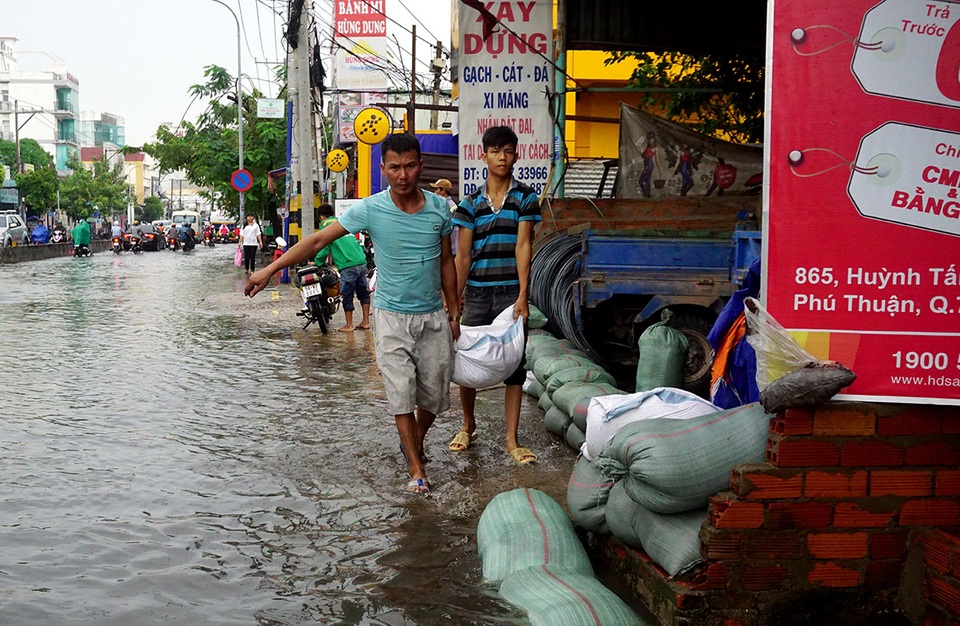 Đường ngập sâu, giao thông "tê liệt" sau cơn mưa lớn ở Sài Gòn - 4 Cửa hàng vật liệu xây dựng phải trữ sẵn nhiều bao cát để ngăn sóng đánh vào.