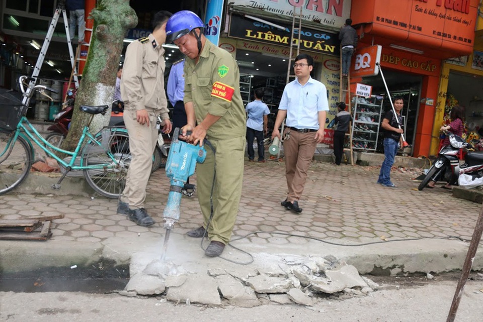 Nhiều tỉnh, thành cùng ra quân giành lại vỉa hè - 2 Lực lượng chức năng tiến hành các biện pháp khoan cắt, tháo dỡ các thiết kế, vật dụng sai quy định trên tuyến đường Phan Đình Phùng.