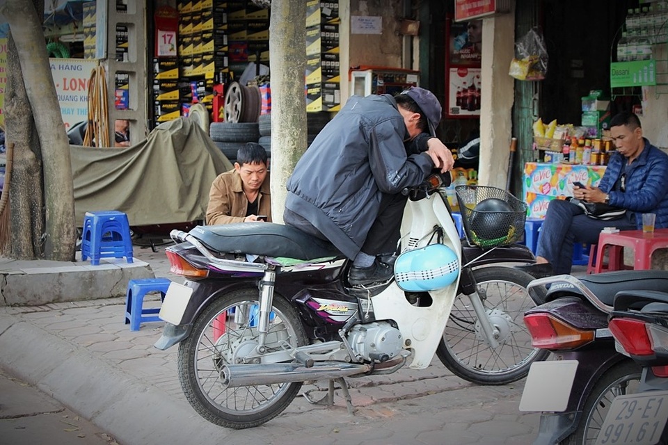 Chiếc xe máy là cần câu cơm, nhưng khi cần có thể ngay lập tức biến thành chiếc giường để bác xe ôm chìm vào giấc ngủ ngắn ngủi. Chỉ nghe loáng thoáng tiếng chân dừng bước, bác đã vội ngẩng lên để chắc chắn không bỏ lỡ bất cứ người khách nào.