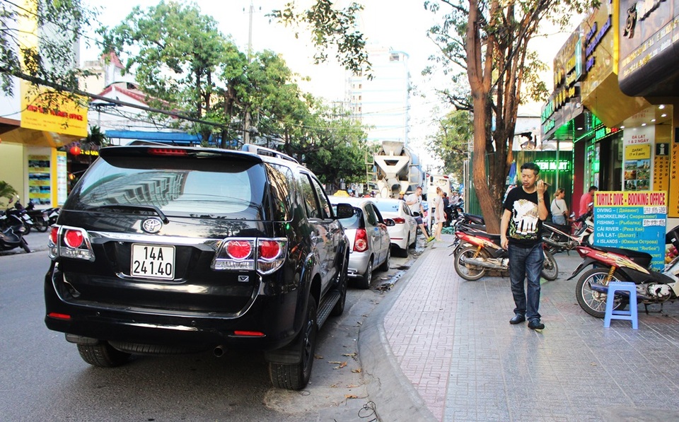 Trên đường Trần Quang Khải, du khách phải luồn lách vì ô tô dừng đậu kéo dài, còn vỉa hè thì bị một công trình xây dựng đang rào tôn ôm gọn