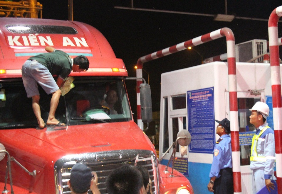 Toàn cảnh cuộc so găng giữa “thượng đế - tài xế” và BOT Cai Lậy - 12
Đặc biệt, trong buổi tối thu phí ngày 2/12, một tài xế cho xe đậu trước barie rồi leo lên mui xe lau kính...
