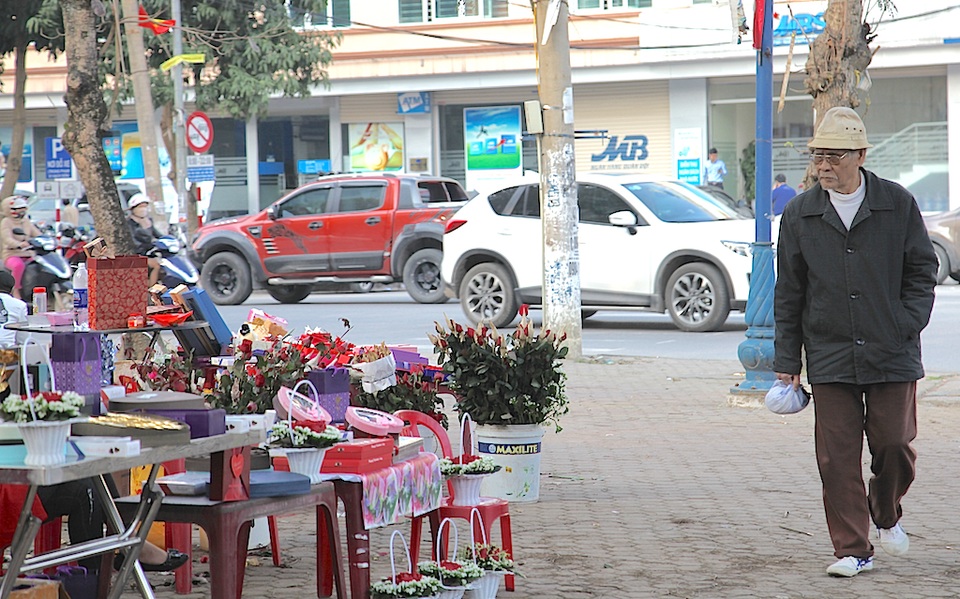 Một cụ ông ghé qua hàng hoa trên đường Minh Khai.