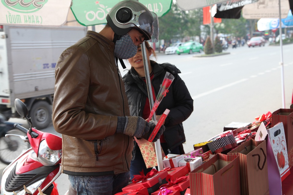 Người đàn ông này chọn cho mình một bông hoa hồng nhỏ và hộp chocolate tặng người yêu.