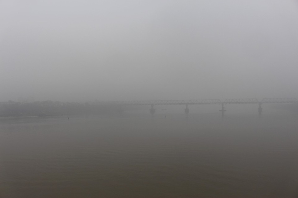 Ở khu vực sông Hồng, khắp nơi chỉ thấy bao phủ một màu trắng xóa. Cầu Chương Dương khó có thể nhìn thấy vì bị lẫn trong sương. Nếu tham gia giao thông vào sáng sớm, các phương tiện phải bật đèn mới có thể nhìn rõ đường.