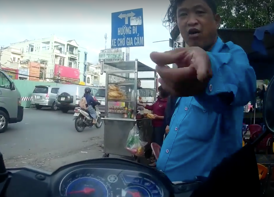 Tài xế Grab bị nhóm xe ôm truyền thống vây đánh ở bến xe An Sương - 1 Ngay khi anh Luân dừng xe thì bị người đàn ông này đến hăm doạ, đuổi đi (ảnh cắt từ clip)