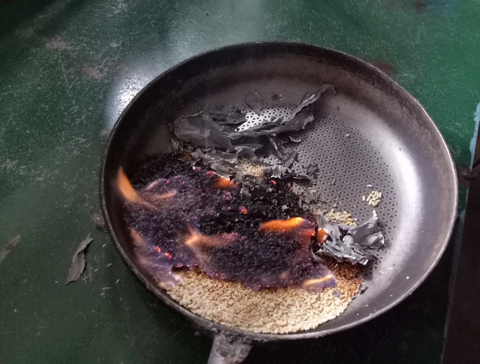 Thu hồi gạo hỗ trợ lũ lụt bị chảy nhũn, kết mảng khi cháy - 1 Sau khi rang sơ qua và mang đốt, số gạo hỗ trợ bắt lửa bốc cháy rất nhanh