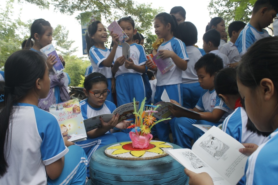 Thư viện lưu động làm từ vật liệu phế thải thu hút học sinh - 2 Học sinh trường Tiểu học Nghĩa Chánh hào hứng đọc sách bên những vật dụng xinh xắn được làm từ vật liệu phế thải