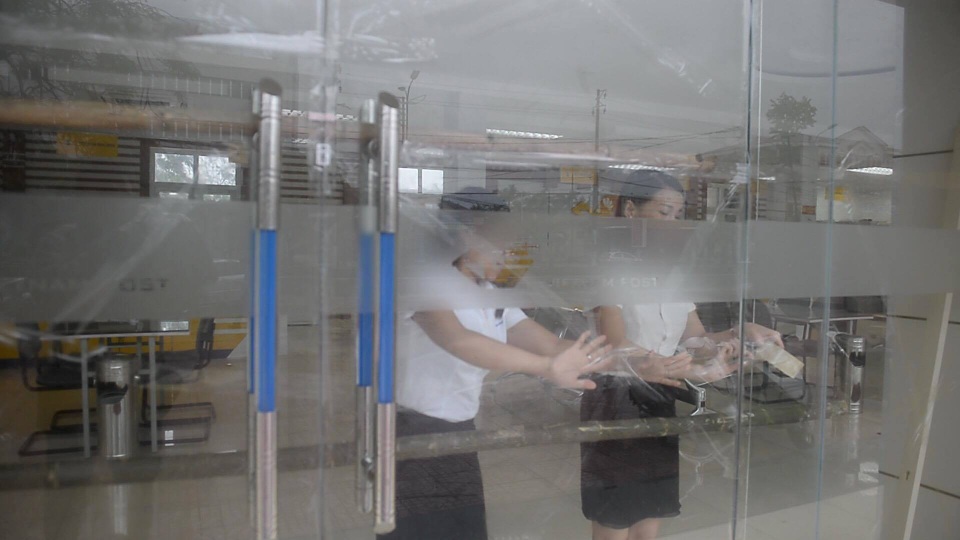 Cộng đồng mạng chia sẻ loạt ảnh hậu quả "xé lòng" của cơn bão số 10 - 16 Nhân viên văn phòng dán cửa kính để tránh nứt vỡ vì sức gió.