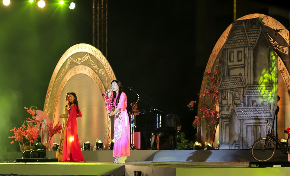 Hồ Quỳnh Hương khởi đầu buổi tối tại đêm nhạc với ca khúc Hà Nội 12 mùa hoa. Cô hút hồn khán giả khi diện tà áo dài cách điệu tông hồng. Kết hợp với kiểu tóc vấn thừng nửa đầu, trông cô vô cùng duyên dáng và yêu kiều.