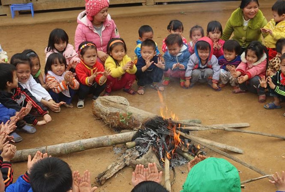 Lạnh 4 độ C, học sinh nhiều nơi phải nghỉ học - 1 Các em học sinh mầm non ở bản Ngàm, xã Tam Thanh, huyện Quan Sơn (Thanh Hóa) ngồi sưởi ấm từ đống lửa cô giáo đốt lên. (Ảnh: Hoàng Lam)