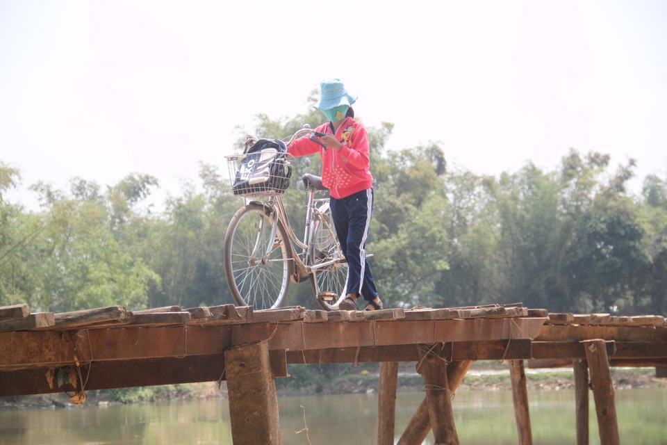 Học sinh liều mình qua cầu tạm vượt sông Kôn đến trường - 2 Em Hà Thị Minh Tâm (lớp 6A1 trường THCS Nhơn Mỹ), cho biết: “Ngày ngày em phải đi qua cầu tạm này từ 2-4 lần cả đi và về. Nhiều bạn liều ngồi lên xe đạp đi cầu nhưng em sợ té rớt xuống sông nên phải dắt xe bộ qua cầu. Sợ nhất là khi trời gió lớn đi ra đến giữa cầu gió mạnh muốn xô xuống sông”.