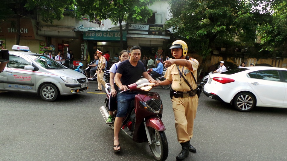 Với việc đưa con đi học từ sáng sớm, nhiều phụ huynh không đội mũ bảo hiểm cho cả mình và con vì nghĩ rằng lực lượng CSGT chưa làm nhiệm vụ.