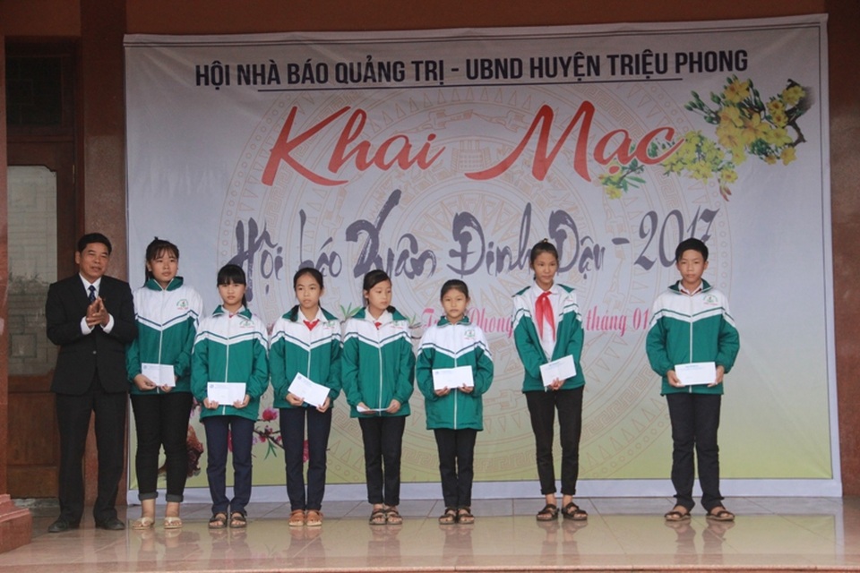 Ông Trần Đăng Mậu thay mặt những người làm báo tặng quà cho các em học sinh có hoàn cảnh khó khăn