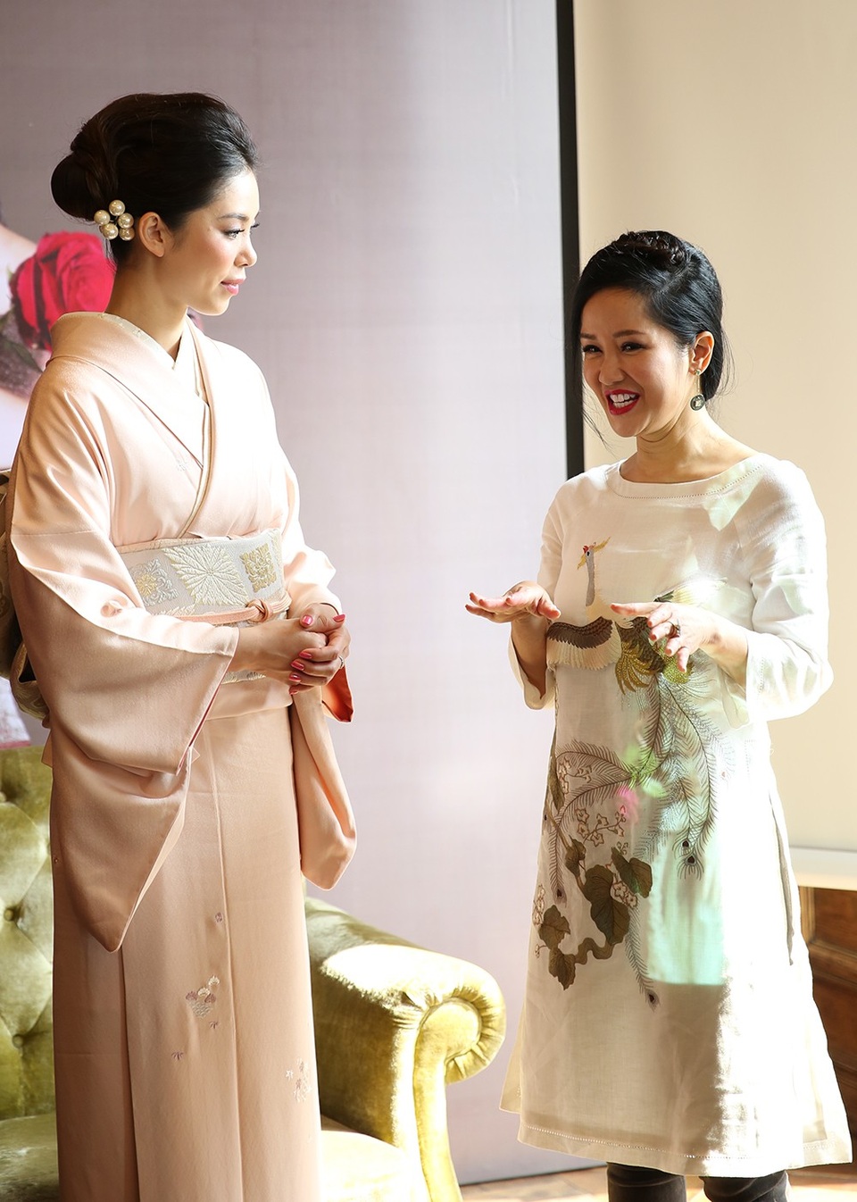 Hai con song sinh của Hồng Nhung quấn quýt mẹ không rời - 11 Hồng Nhung trò chuyện thoải mái và thân thiện cùng Hoa hậu Riyo Mori. Người đẹp đến từ Nhật khen họa tiết con công độc đáo trên áo dài của Hồng Nhung.