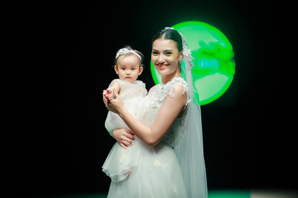 Nữ người mẫu diện bộ váy trắng bồng bềnh, đội khăn voan như cô dâu, bế con gái cưng kết lại màn trình diễn. Sự xuất hiện của hai mẹ con Hồng Quế nhận được sự ủng hộ đông đảo từ các khán giả.