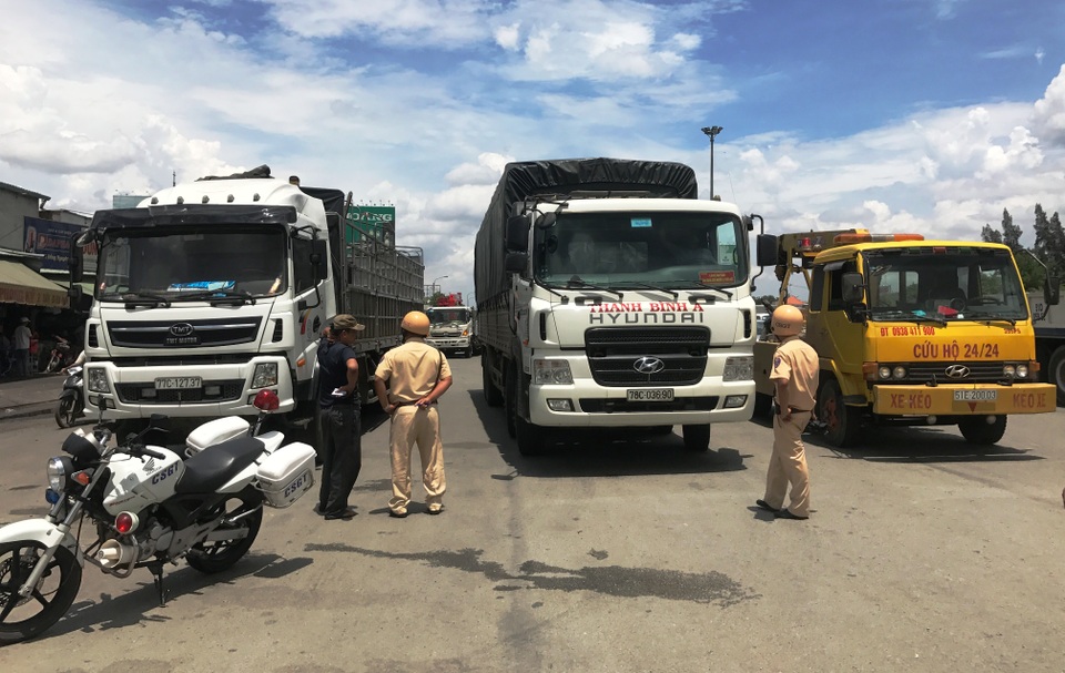 Xử phạt hàng loạt tài xế “dàn hàng” xe giữa đường để... ăn cơm trưa - 1 Lực lượng CSGT xử lý xe tải dừng đỗ trái phép trên QL1 trưa ngày 10/5.