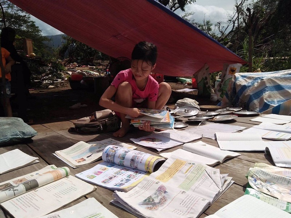 Em Đinh Nữ Như Quỳnh, một học sinh tại huyện Minh Hóa đang phơi lại sách vở bị ướt trong bão để có sách phục vụ học tập.