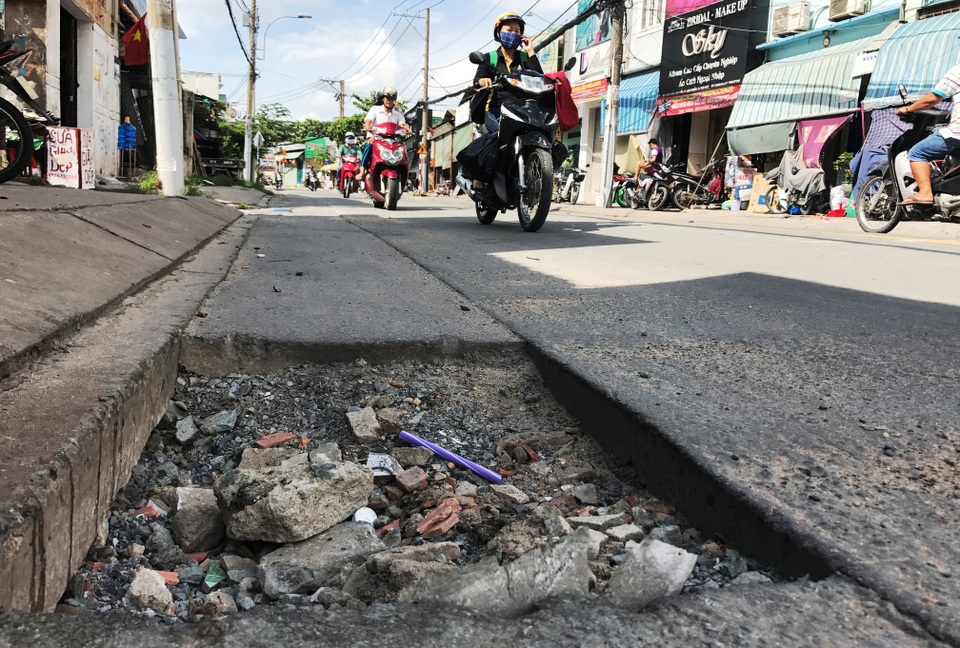 Đường đầy hố sâu nguy hiểm sau mưa lớn - 4 Tuyến đường này luôn tấp nập xe tải, container, xe buýt...lưu thông hỗn hợp cùng xe máy, vì vậy tính mạng người dân đang trong tình trạng bị đe dọa.