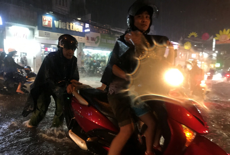 Người Sài Gòn lại khốn đốn với điệp khúc "mưa lớn - ngập nặng - lội bì bõm" - 6
Một chiến sĩ Công an phường Linh Chiểu, quận Thủ Đức giúp đỡ người dân trên đường nước chảy siết.