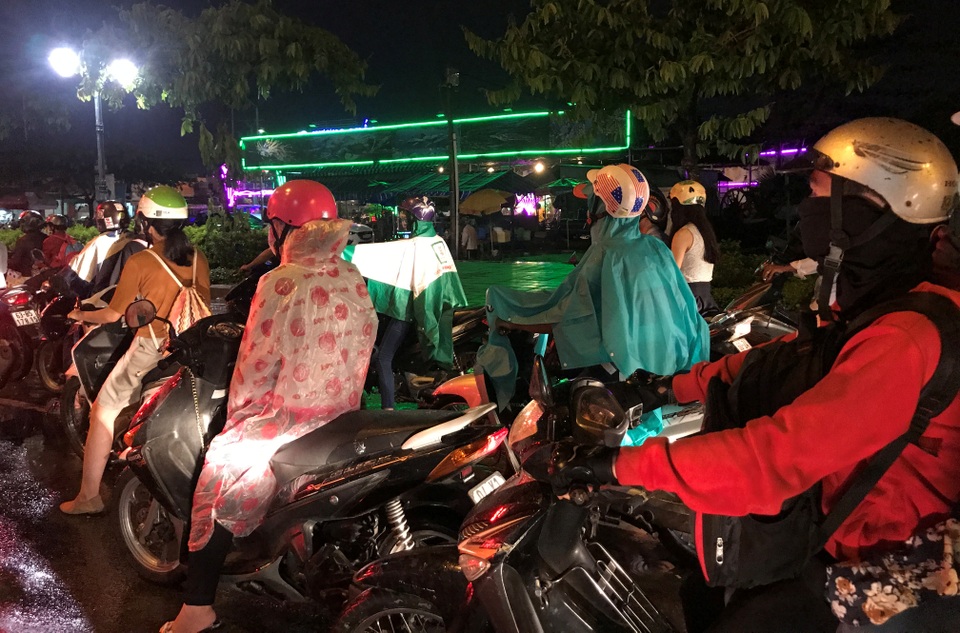 Người Sài Gòn mặc áo ấm, người Hà Nội mướt mải vì nóng 41 độ C - 7 Nhiều người có việc đi lại trên đường phải trùm kín áo mưa, áo ấm để tránh mưa lạnh.