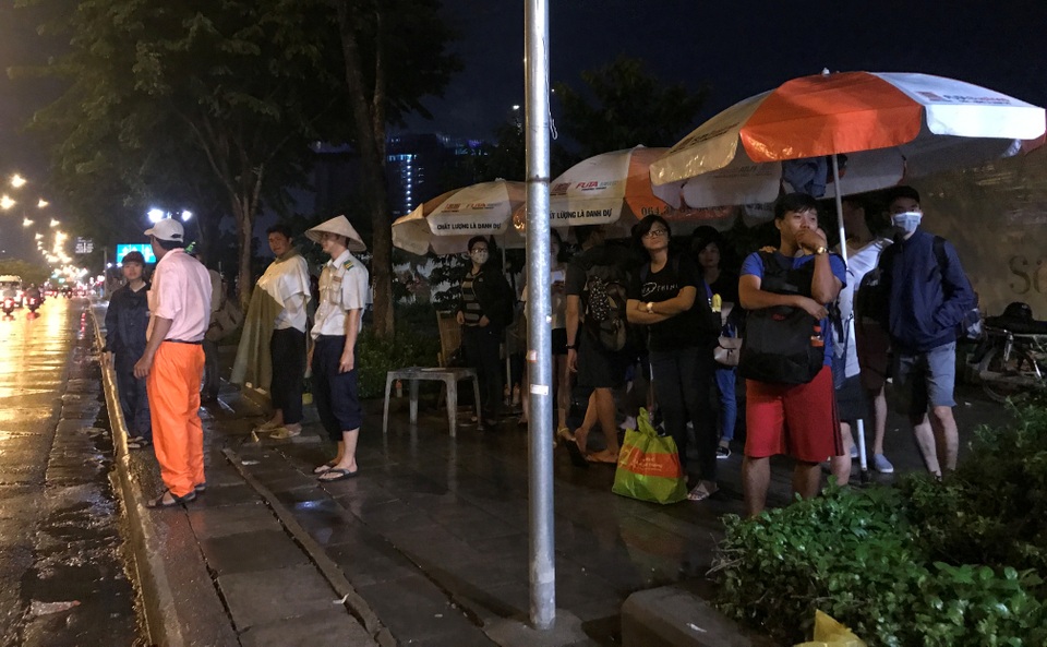 Người Sài Gòn mặc áo ấm, người Hà Nội mướt mải vì nóng 41 độ C - 3 
Người đi đường co ro trong thời tiết mưa gió đón xe để trở về nhà trên đại lộ Mai Chí Thọ, quận 2, TPHCM trong tối 4/6.