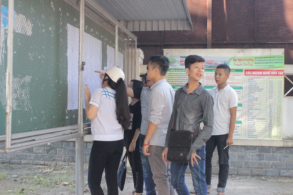 
Các thí sinh đến sớm xem lại số báo danh và phòng thi. (Ảnh: Phượng Vũ)
