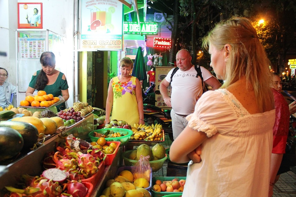 Du khách Nga không thể bỏ đi trước một kệ trái cây bắt mắt, hấp dẫn trên đường phố Nha Trang. Sau đó họ mua một ít để thưởng thức hương vị trái cây của đất nước có khí hậu nhiệt đới gió mùa ẩm