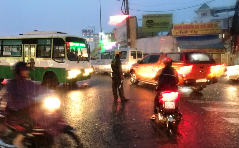 Mưa trái mùa cực lớn, kéo dài nhiều giờ chiều mùng 6 Tết ở Sài Gòn - 16 Cảnh sát giao thông thuộc Đội Tuần tra dẫn đoàn (PC67, Công an TPHCM) hướng dẫn phương tiện tìm hướng đi khác, tránh vào vùng ngập nước.