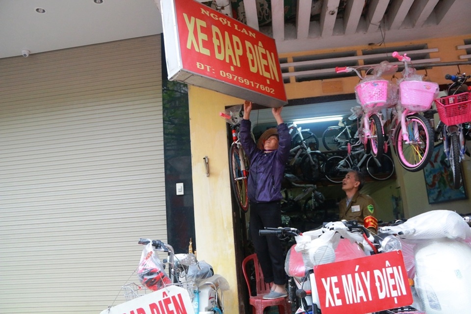 Một hộ dân ở phố Vân Giang, thành phố Ninh Bình tự tháo dỡ biển quảng cáo vi phạm.