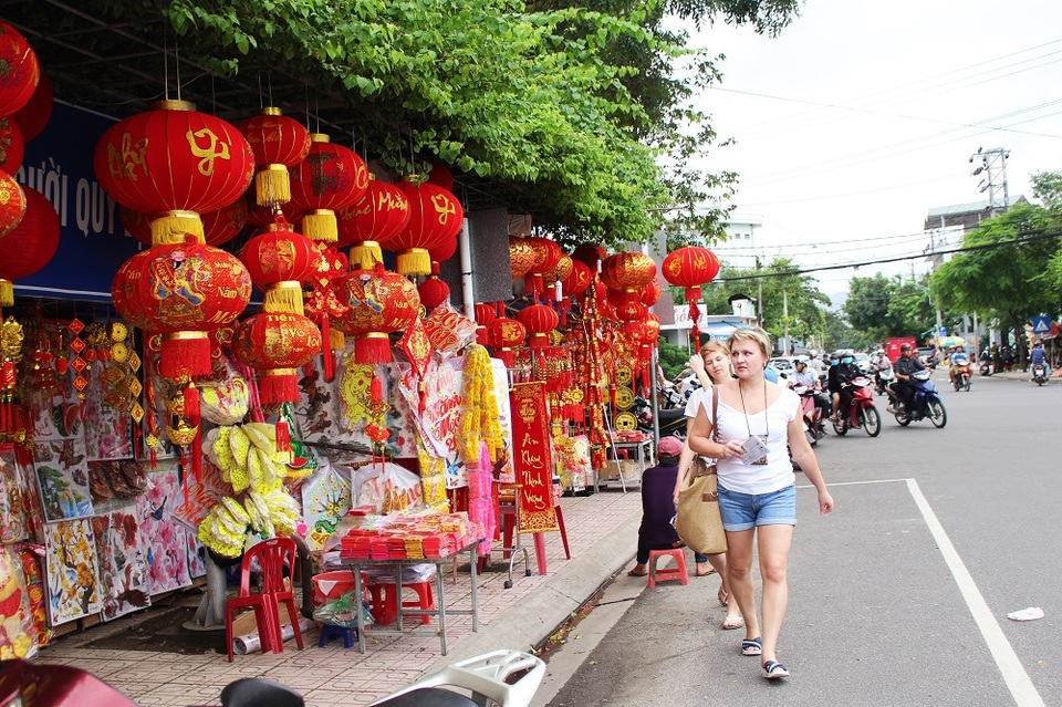 Du khách nước ngoài tản bộ trên một con đường ngập tràn đèn lồng trước thềm Tết Nguyên đán Đinh Dậu
