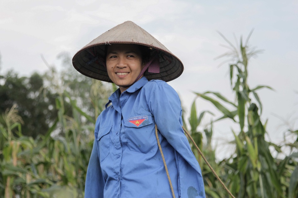 Người mẹ cụt tay chăm con bằng chân khiến bao người rơi lệ - 5 Chị Cậy phải dùng nách, nghẹo đầu để cầm dây, dắt bò. Ảnh: Toàn Vũ