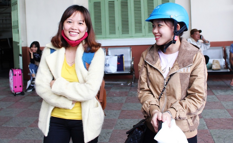 Hai chị em ruột Hoa và Lệ háo hức đợi tàu để về quê Quảng Trị ăn Tết. Người chị (mũ xanh) cho biết đang làm việc cho một doanh nghiệp bảo hiểm ở TP Nha Trang nhưng xin nghỉ nửa ngày để kịp cùng em gái về quê đón Tết. Em đặt vé về quê từ tháng 11 năm ngoái, nguyên chặng từ TP HCM - Hà Nội, với giá 1,7 triệu đồng, người chị nói