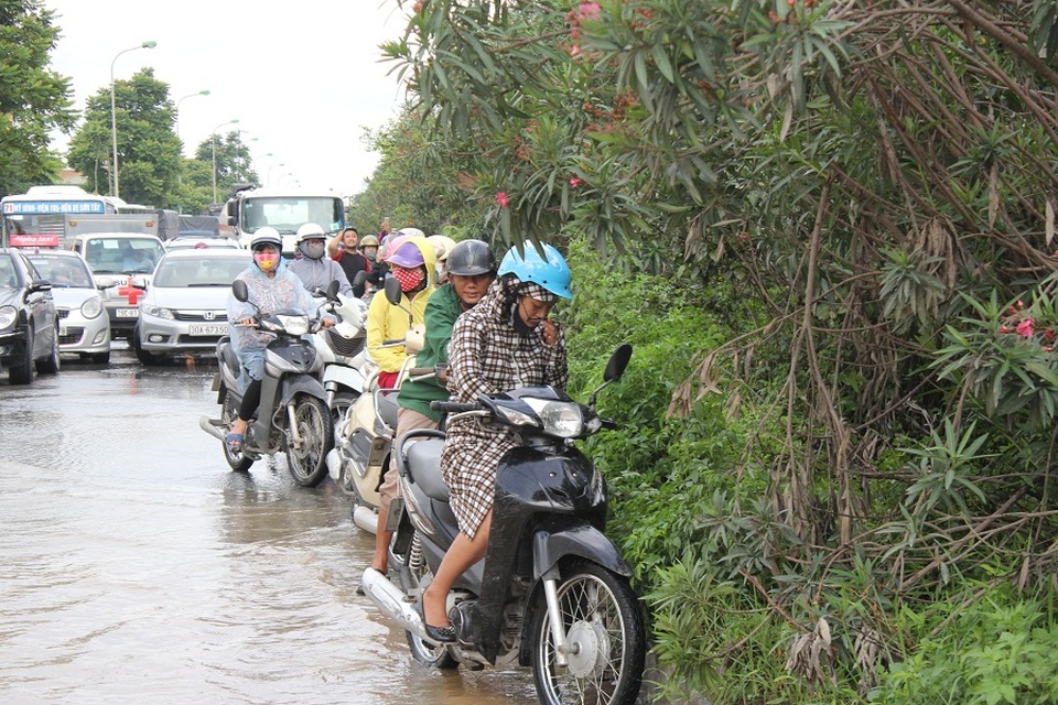 Hàng nghìn người vật vã "lội sông" trên đại lộ hiện đại nhất Việt Nam - 4 Hàng đoàn xe máy nối đuôi nhau gây ra cảnh ùn tắc kéo dài. Theo phản ánh của người dân, nước bắt đầu ngập từ khoảng 8h sáng ngày 13/7 đến trưa cùng ngày vẫn chưa có dấu hiệu rút.