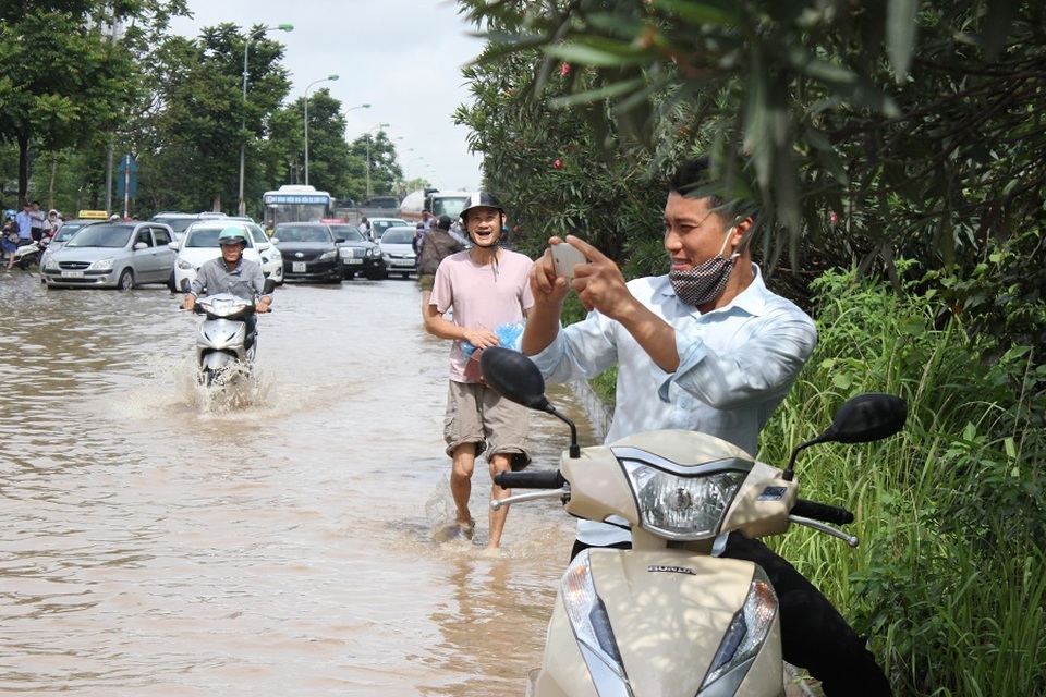 Hàng nghìn người vật vã "lội sông" trên đại lộ hiện đại nhất Việt Nam - 10 Một người dân thích thú chụp ảnh cảnh vượt lũ trên đại lộ hiện đại nhất Việt Nam.