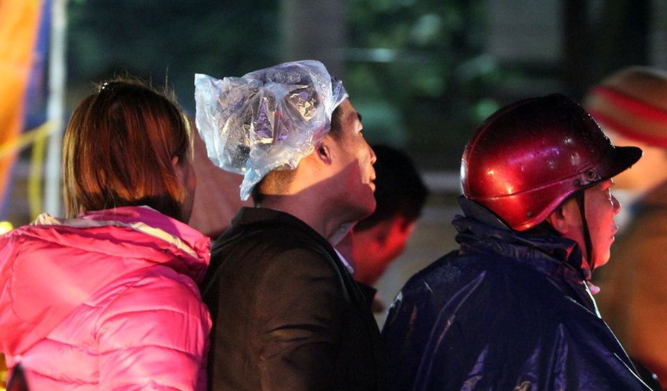 
Nhiều người dùng túi nylon để che mưa, chen chân đi chợ.
