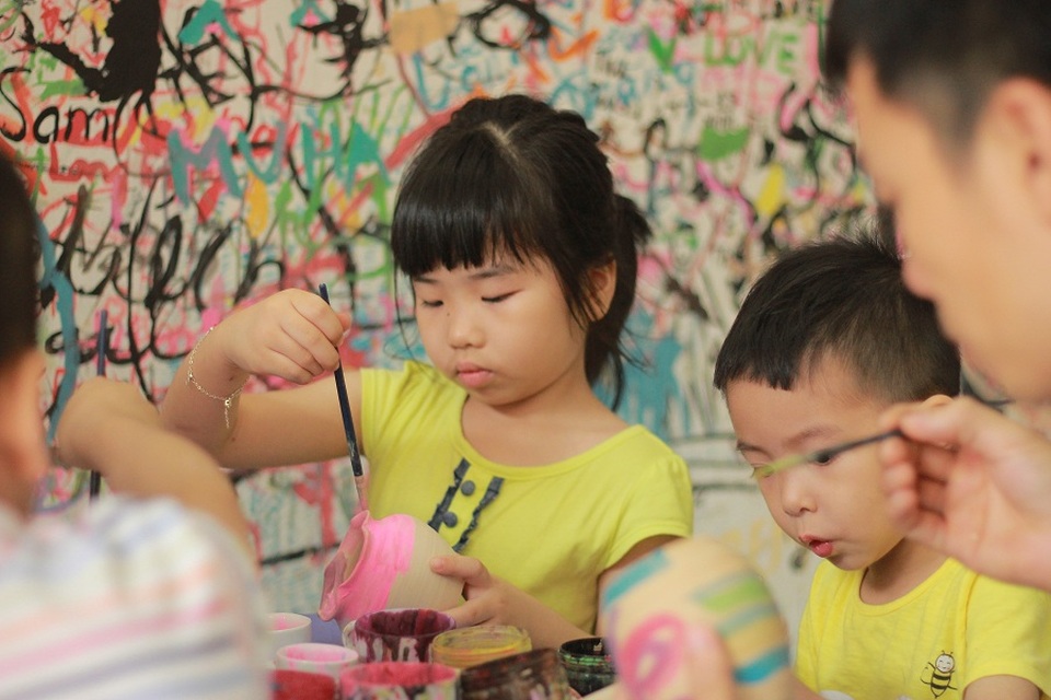 Các em nhỏ hào hứng vẽ hoa văn lên các sản phẩm gốm, sứ