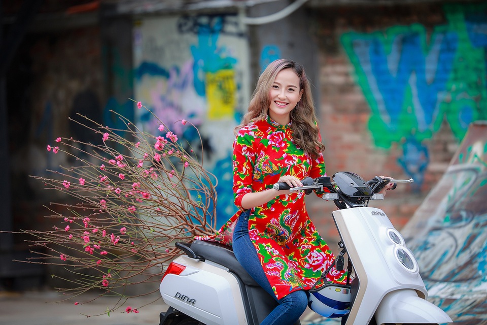 Khánh Ngân xinh đẹp đến ngẩn ngơ trong tiết xuân Hà Nội - 2
Trong sắc áo dài rực rỡ pha chút hoài niệm, Khánh Ngân diện theo cách của các bạn trẻ là kết hợp với quần Jeans, khăn len ấm, khiến set đồ trở nên tinh nghịch, dễ thương. Vẻ đẹp rực rỡ cùng nụ cười toả nắng ngọt ngào của cô thật gây thương nhớ với Xuân Hà Nội. Trong tiết trời Xuân Hà Thành, Khánh Ngân thích thú khi diện những chiếc áo dài chăn con công của NTK Hữu Anh Zon mà gần đây giới trẻ đang phát cuồng, đi xe đạp điện Dina, dòng xe mà cô yêu thích, chở cành đào Nhật Tân thong dong, mơ mộng hưởng khí Xuân Hà Nội.