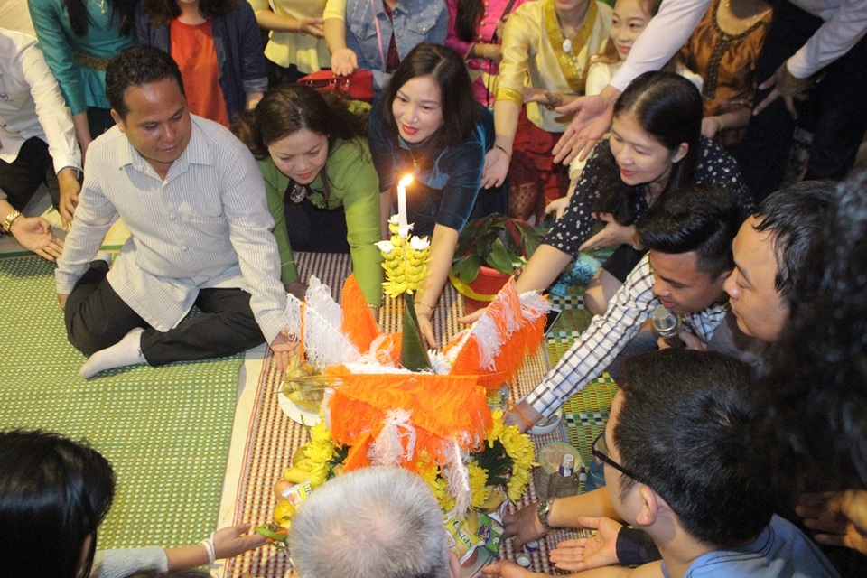 Hà Tĩnh: Đầm ấm Tết cổ truyền của Lào tại giảng đường Đại học - 1 Trong suốt thời gian tế lễ mọi người tham dự đều đặt tay gần với mâm lễ vật, những người phía sau đặt tay lên vai người phía trước.